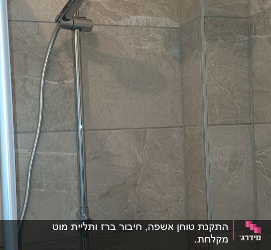 ראש מקלחת וכפתורי שליטה על קיר אריחים